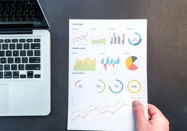 a person holding a piece of paper with a chart of graphs