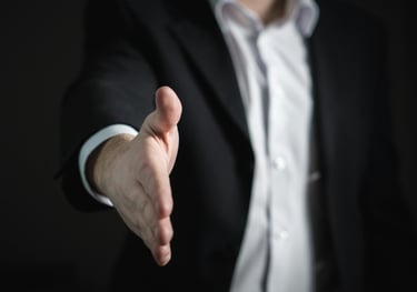 a man in a suit and tie is holding a hand out to a hand
