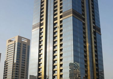 Modern commercial skyscraper in Middle Eastern / Gulf financial district, showcasing sleek glass facade and dark navy and gold architectural details under bright sunlight.