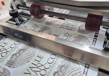 Industrial label applicator machine printing Valle San Rocco Prosecco wine bottle labels.