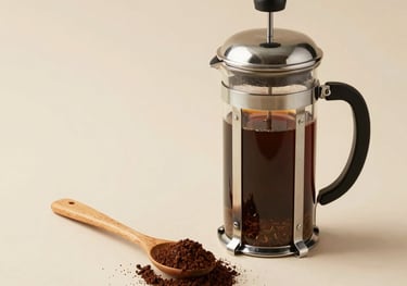 Minimalist composition of a French press next to a wooden spoon with coffee grounds, neutral beige background, clean and airy aesthetic.