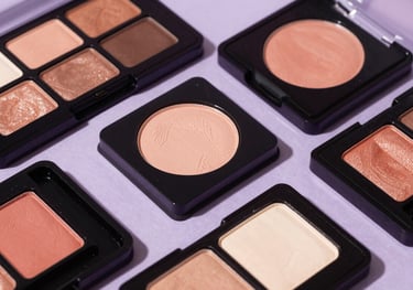 Close-up of high-quality eyeshadow palettes with vibrant colors, arranged artistically on a light purple surface, studio lighting, elegant style.