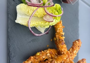 Assiettes de tapas variées et verres en terrasse de la brasserie vintage Le Loan.