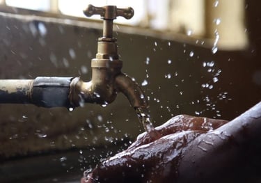 Lavage de mains sous un robinet en laiton vintage et ses éclaboussures de gouttelettes.