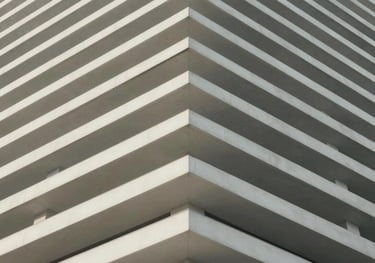 An abstract, architectural photography shot of clean white lines leading toward the corner of a building, symbolizing upward growth and structured progress.