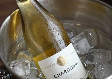 A bottle of Chardonnay in an ice bucket, with subtle condensation and soft light catching the light gold color of the wine inside.