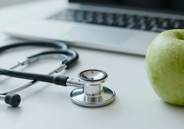 A close-up of a professional office desk with a stethoscope and a fresh green apple. Sophisticated and light aesthetic with #8FBBA6 tones.
