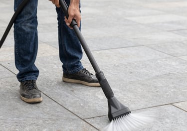 A sparkling clean stone patio surrounded by lush greenery after pressure washing.