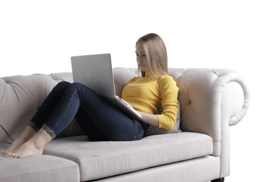 a woman sitting on a couch with her legs crossed receiving online grief therapy
