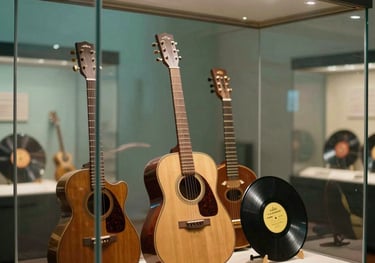 Detailed shot of unique Beatles memorabilia, including vintage instruments and rare records, presented behind crystal clear museum glass in a premium Buenos Aires venue. Lighting is soft teal and warm gold.