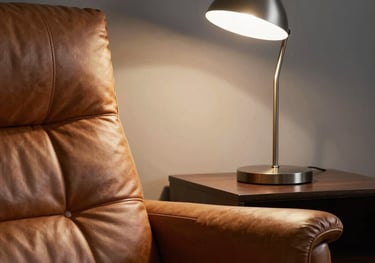 Close-up of a high-quality leather chair and a sleek modern lamp in a quiet, shadowy study, emphasizing an atmosphere of exclusive personal development.