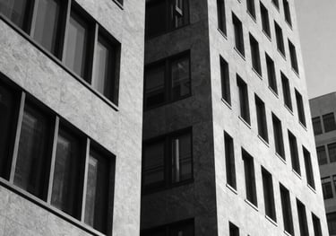 Black and white photography of a modern architectural detail in a North American corporate building, focusing on sharp geometric lines and shadows to represent discipline and structure.