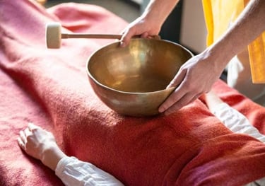 A Tibetan sound bowl resting on a person's body during a sound healing session