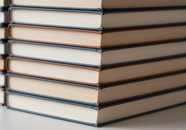 A stack of hardcover books with beige and brown spines, arranged neatly on a light surface. Clean, professional, literary composition.