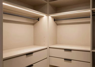 Interior shot of a luxury walk-in closet with beige cabinetry, black hardware, and elegant integrated LED lighting, reflecting a timeless design style.