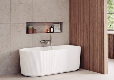Modern white fluted freestanding bathtub in a luxury bathroom with beige stone tiles and wood wall paneling.