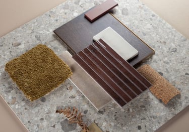 Interior design mood board featuring terrazzo tile, dark wood flooring, and olive green carpet samples.