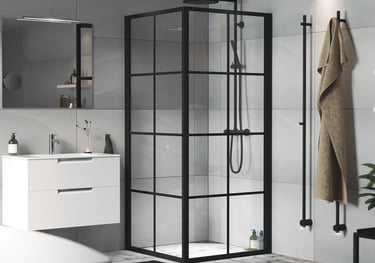 Modern bathroom featuring a black framed glass shower enclosure and a white floating vanity.