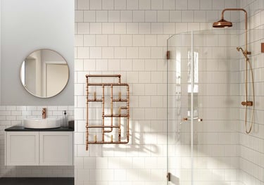 Modern bathroom featuring a copper pipe towel radiator, walk-in shower with copper hardware, and white subway tiles.
