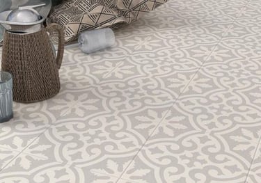 Elegant grey and white patterned ceramic floor tiles with a vintage fleur-de-lis inspired design.