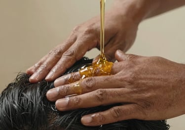 Close-up photography of golden Brahmi oil being massaged into a scalp, South Asian / Indian setting, focusing on the herbal oil texture and warm, serene lighting.
