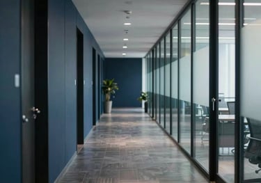 A photography shot of a sleek, modern Bangladeshi office hallway. The composition uses leading lines and soft lighting to create a sense of movement and direction. The professional atmosphere is enhanced by a palette of navy and charcoal.