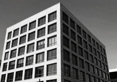 A black and white architectural shot of the modern Meiring Attorneys office building in Cape Town. Sharp angles, high contrast, #0F1113 shadows.