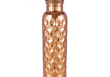 a small copper vase with a gold colored glass jar