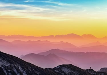 A panoramic view of a mountain wilderness at sunset depicting self-compassion.