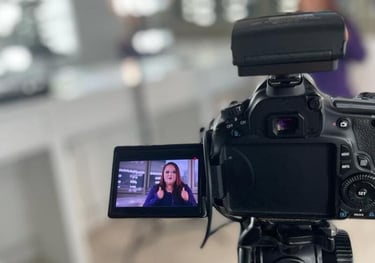 Cámara DSLR profesional sobre un trípode grabando a una presentadora durante una producción