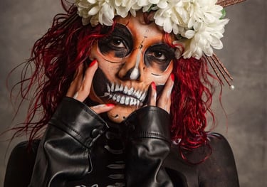Mujer con maquillaje de calavera de azúcar del Día de Muertos con corona floral blanca y cabello roj