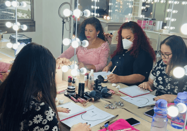 Estudiantes practicando el mapeo de gráficos faciales en una clase de maquillaje profesional