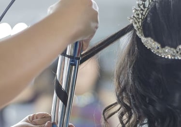 Estilista profesional que utiliza un rizador para peinar el cabello oscuro de una novia 