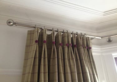 Curtains with stitched double pleats and covered buttons bringing out the purple in the main fabric