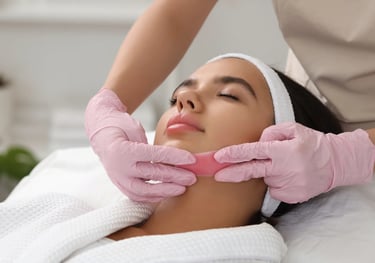 Beautician giving facial treatment to woman at beauty clinic