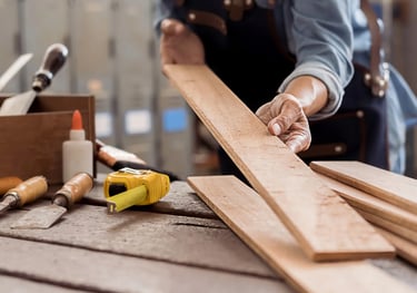 Carpenter working with wooden planks in workshop