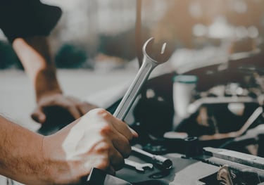 Mechanic repairing a car engine with a wrench