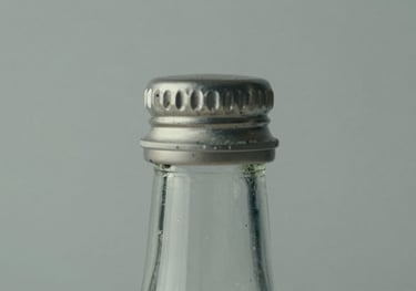 Close-up of high-quality glass packaging and closures for premium beverages, minimalist composition, mist gray background.