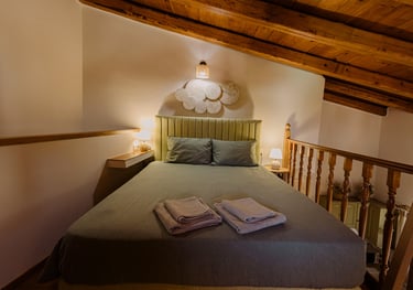 Tonia's Cottage bedroom with a bed and pillows on top of a wooden floor