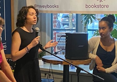 Becca Block holding a microphone speaking