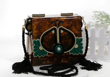 a small tortoid box - top handbag with a green and white flower