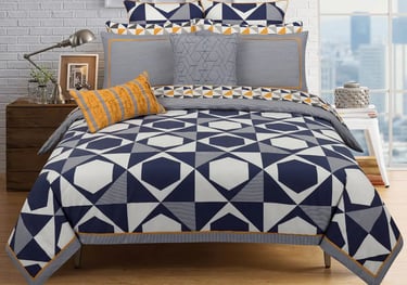 a bed with a blue and white bedding and a white brick wall