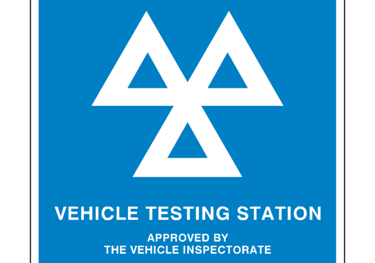 a vehicle testing station with a blue and white sign that says vehicle testing