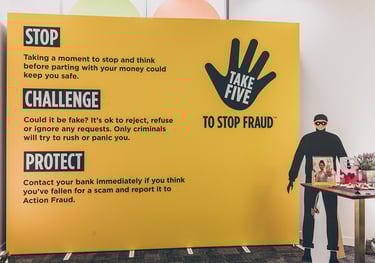 a cardboard thief standing in front of a large banner