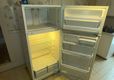 Heavy refrigerator being carried out during appliance removal service