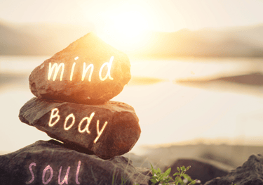 a stack of rocks with the words mind body soul soul