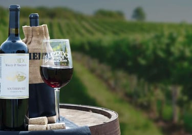 a wine glass and a bottle of wine on a barrel 