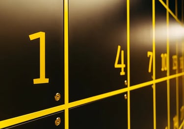 Numbered black lockers with yellow outlines and key locks in a modern storage facility.