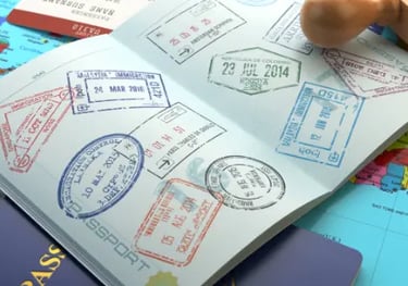 Open passport with international travel stamps on a world map with a wooden stamp.