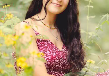 a young lady in a red dress sitting in a field